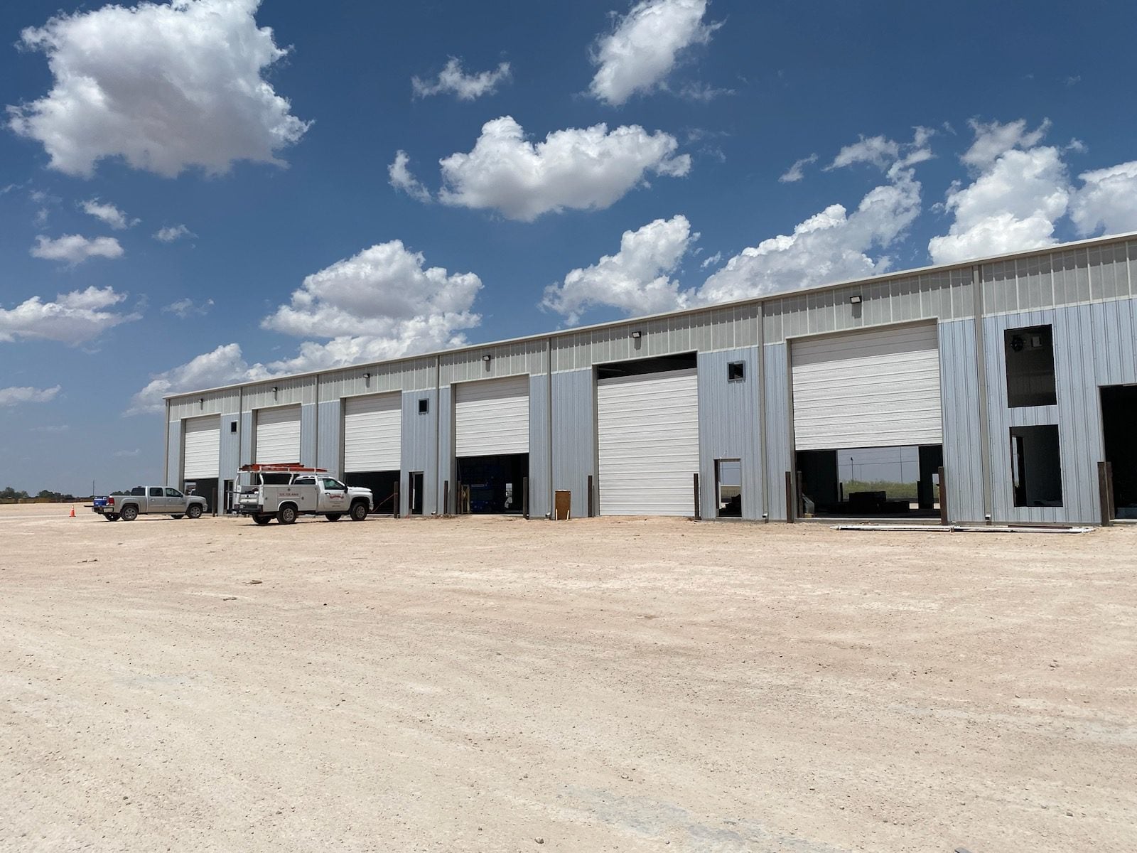 A substantial industrial structure characterized by numerous large doors, highlighting its industrial purpose and scale.