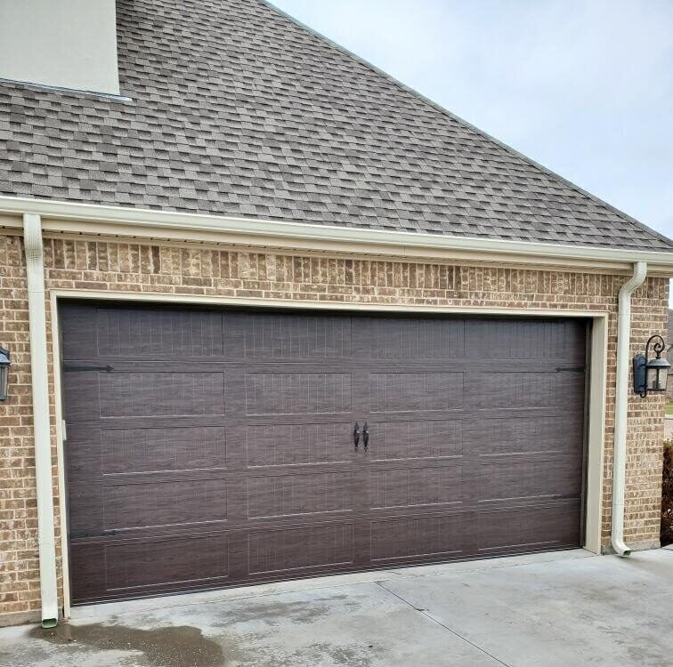 A garage door featuring a rich brown finish, showcasing a sleek and modern design.